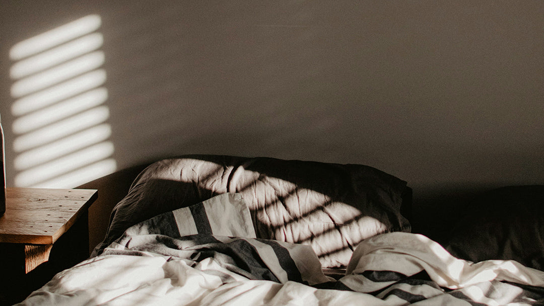cozy unmade bed with morning shadows