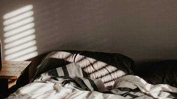cozy unmade bed with morning shadows
