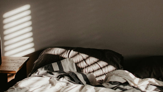 cozy unmade bed with morning shadows